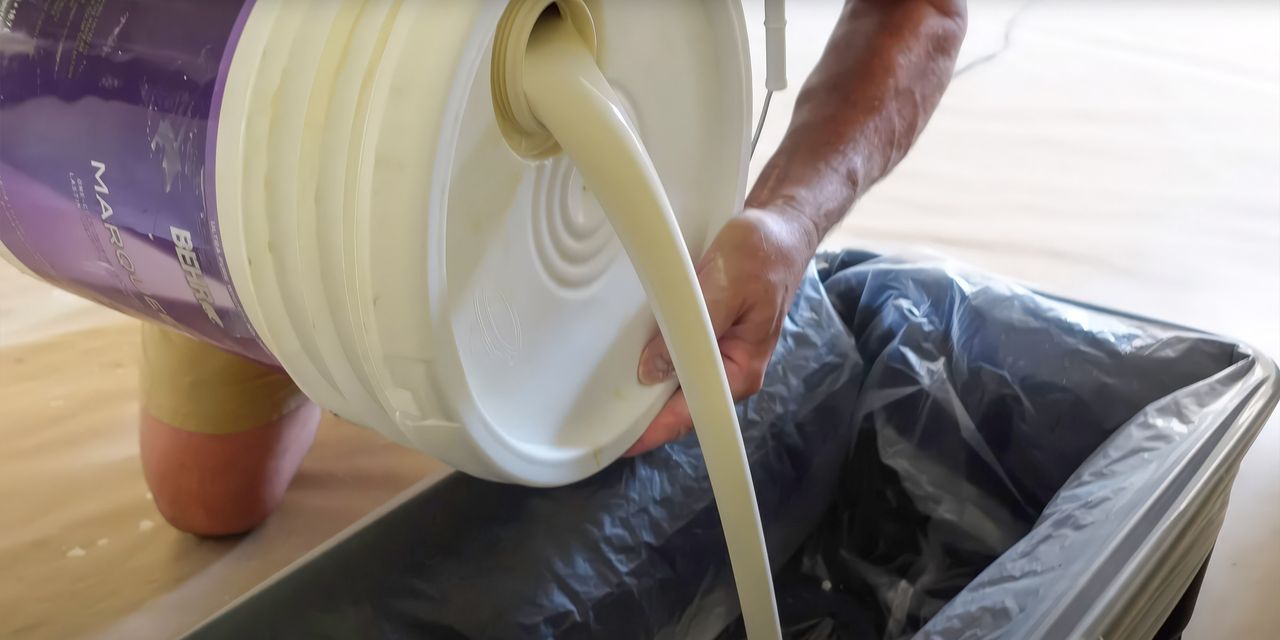Paint being poured into a bucket