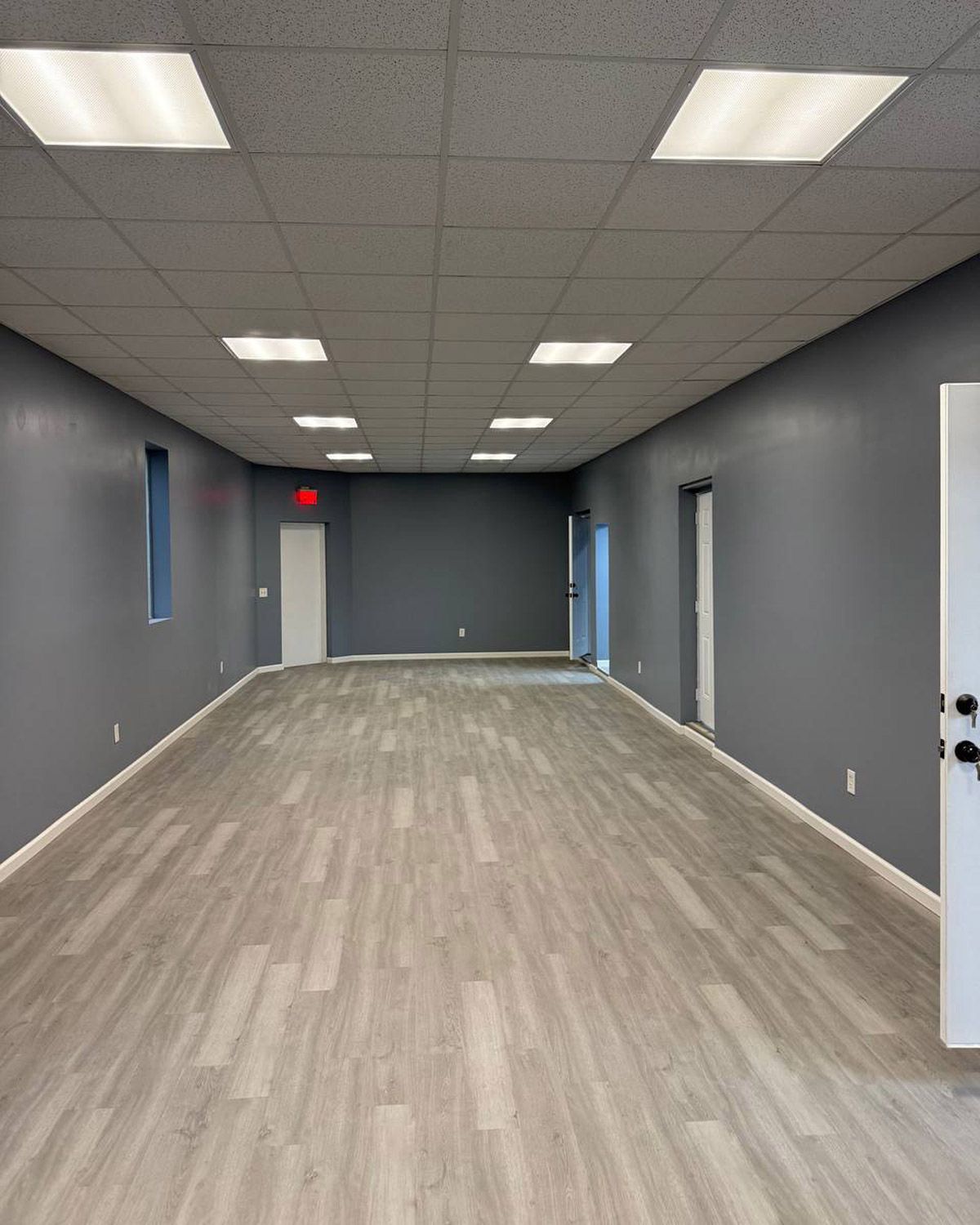 Painted commercial hallway with gray walls and new plank floor