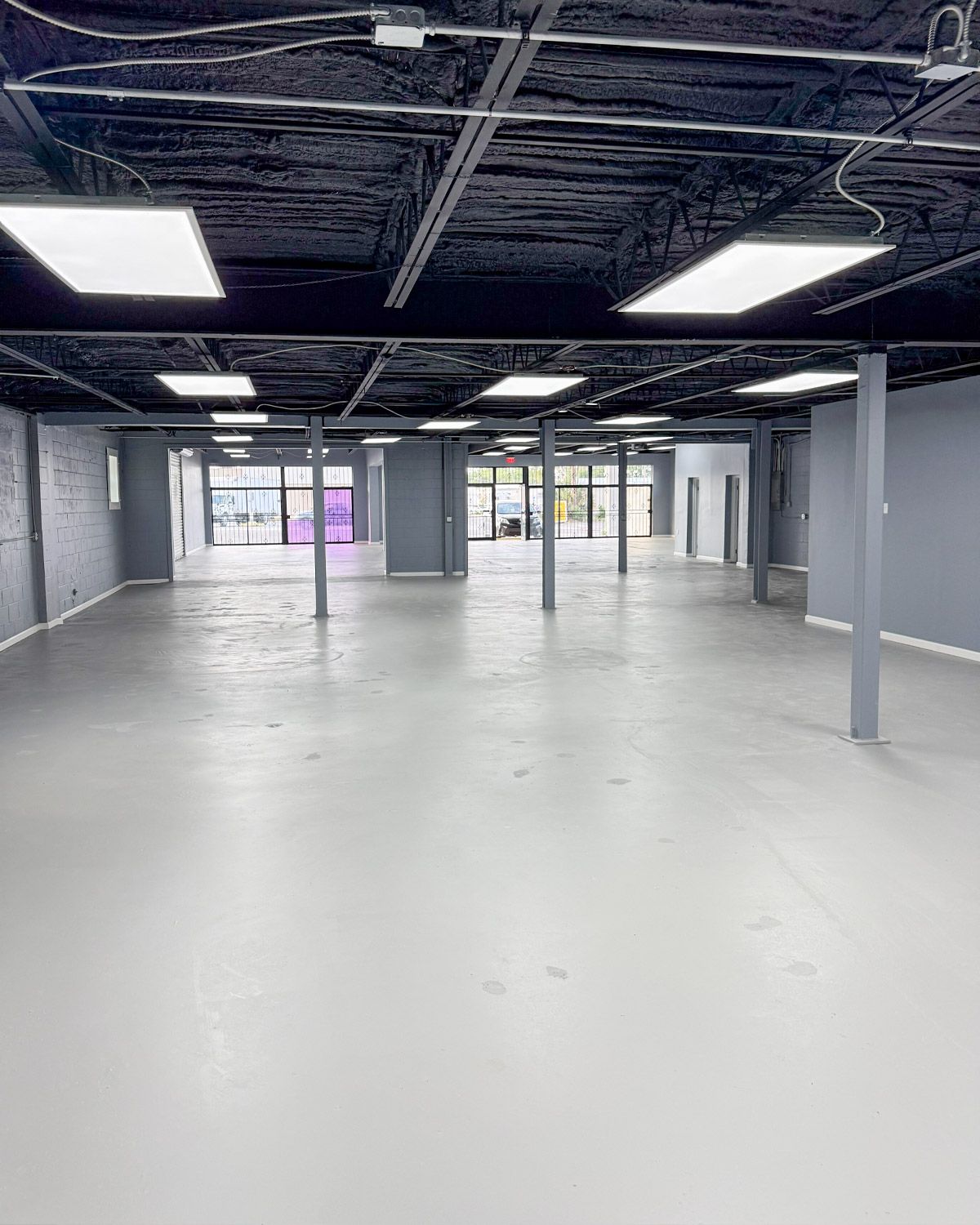 Finished warehouse space with painted walls, columns and a black ceiling