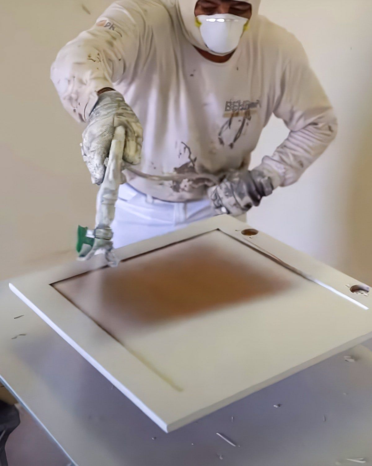 Painter spraying a cabinet door