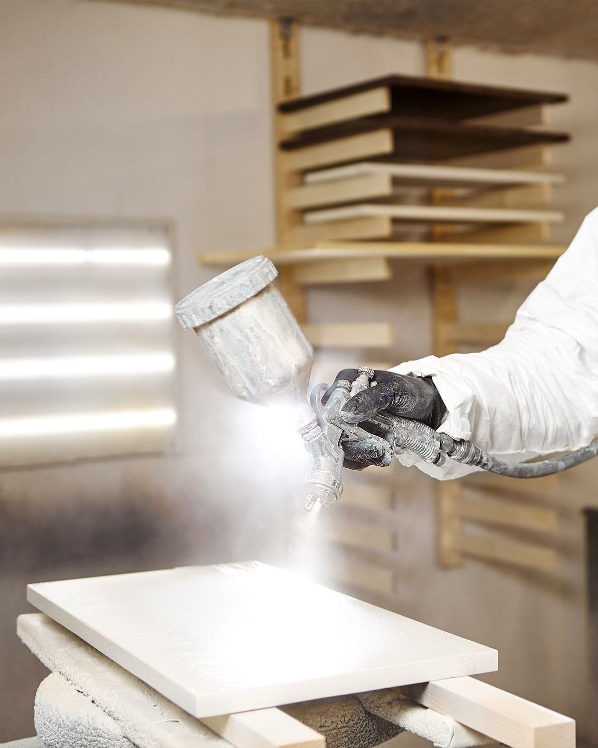Spraying cabinet doors on a drying rack