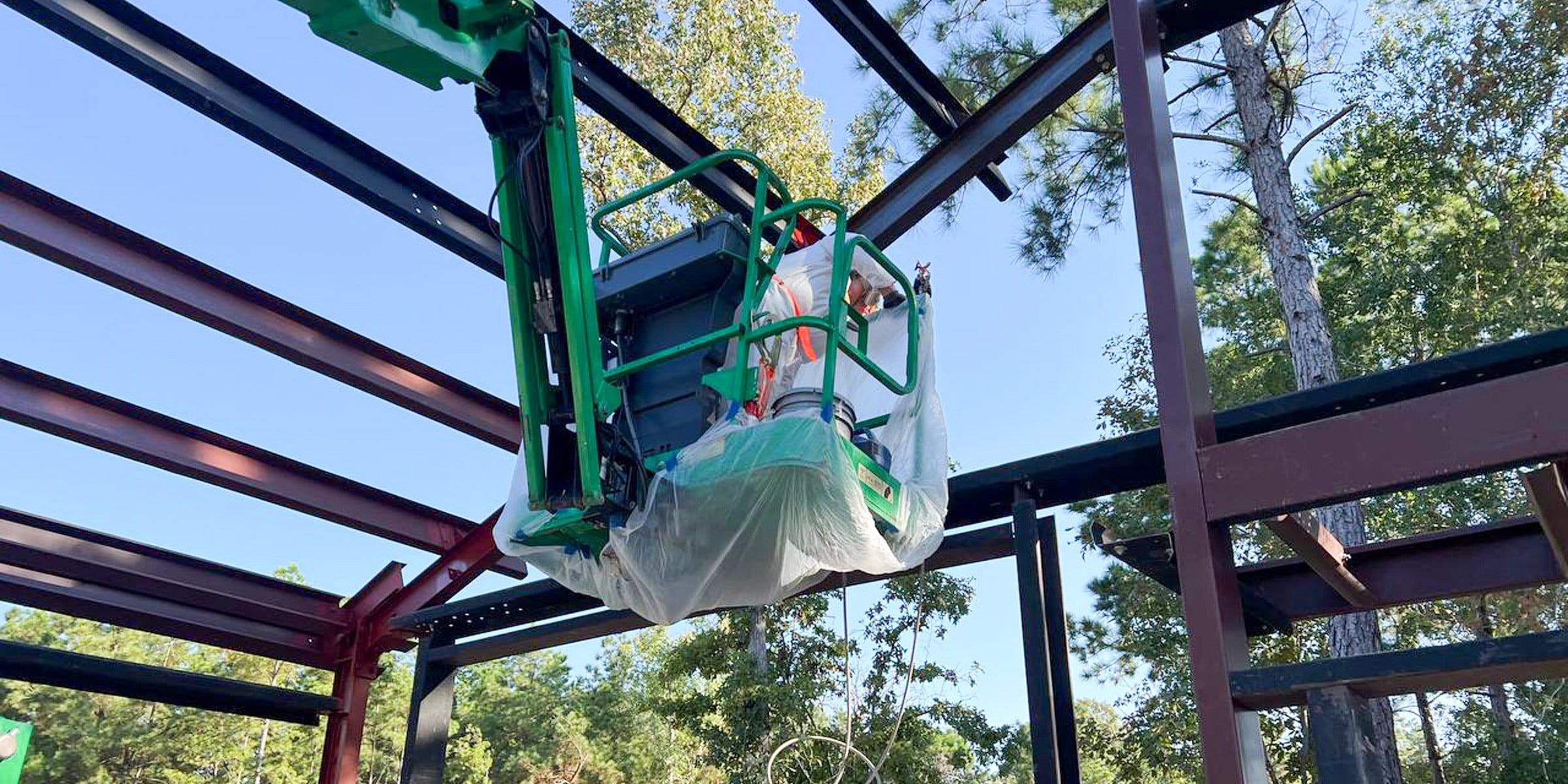 Painter on a lift painting steel beams