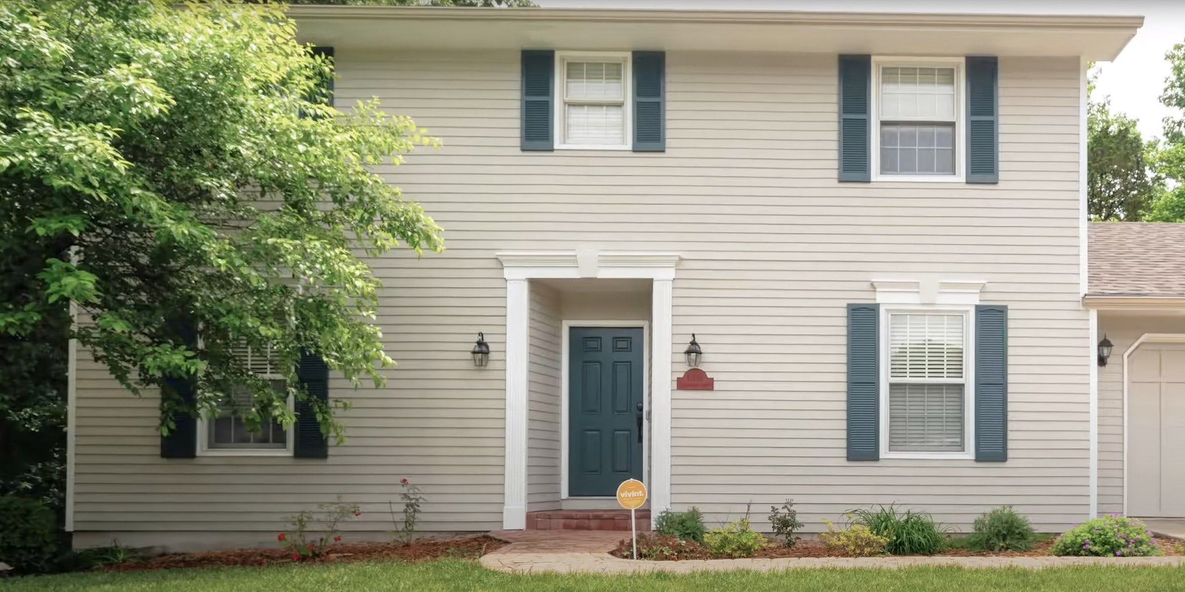 Two-story house with freshly painted siding, trim, shutters and front door