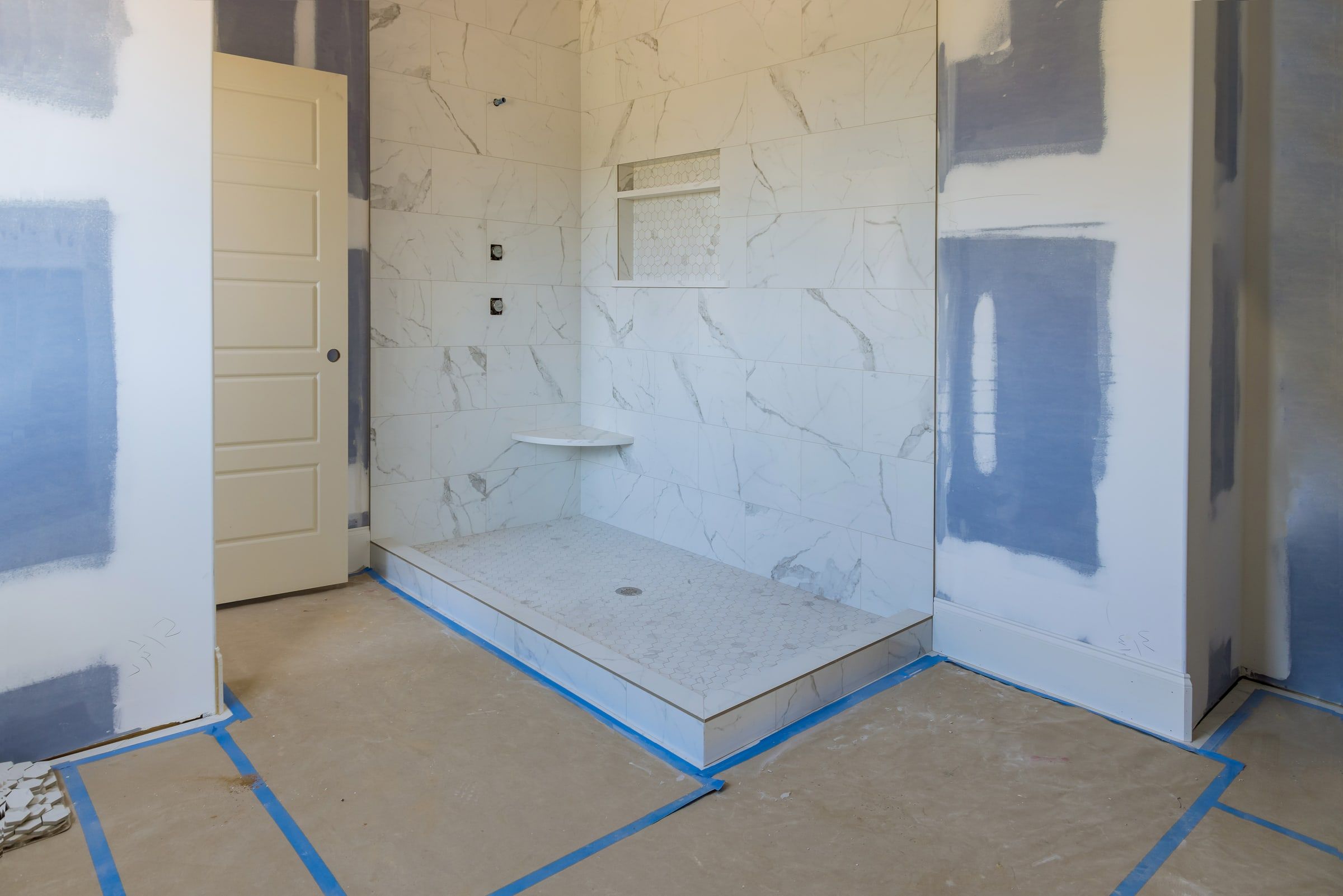 Master bathroom shower and floor tiled during a remodel