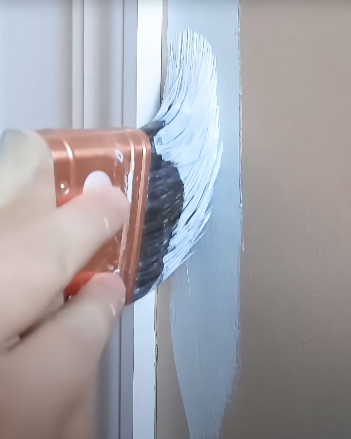 Close-up of a brush cutting in along a wall edge
