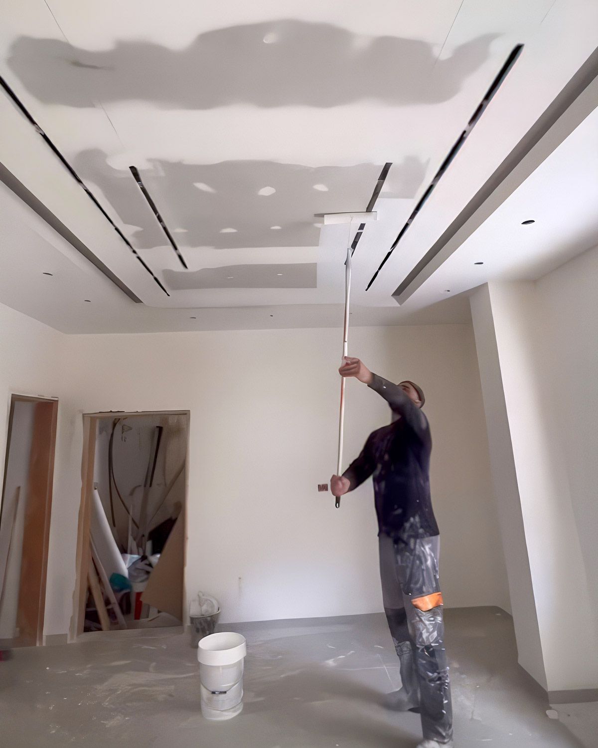 Painter rolling a ceiling with an extension pole