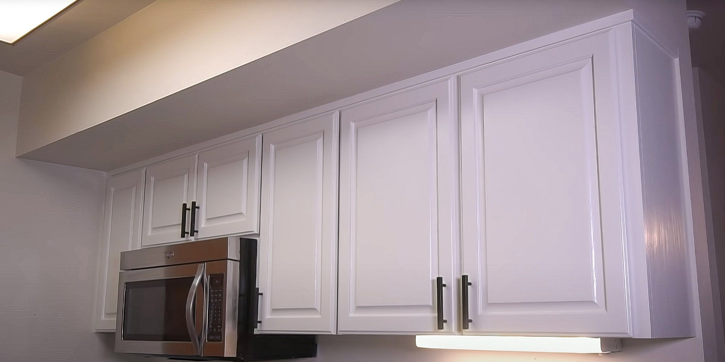The same upper cabinets painted white with black pulls
