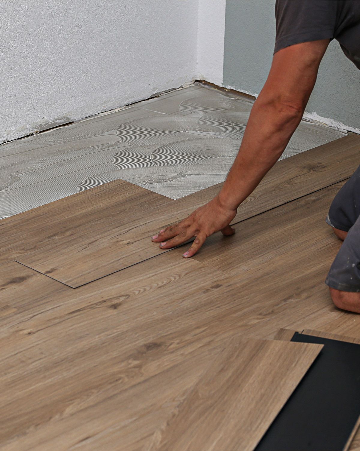 Installer laying vinyl plank flooring